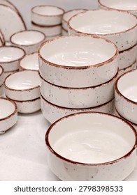 Light ceramic deep plates stacked one on top of another presented as practical tableware set in store display for everyday home use and retail kitchenware sale