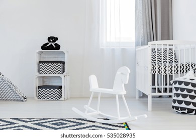 Light child room wite rocking horse, cot and carpet