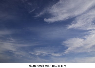 Light clouds in the deep blue sky. Typical signs of weather change. Natural background for graphic projects.