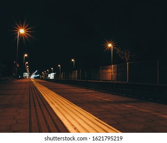 Light Colorful Train Trails At Night. Train Stop In Station. Traffic, Travel Long Exposure Photo