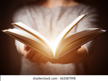Light coming from book in woman's hands in gesture of giving, offering. Concept of wisdom, religion, reading, imagination. - Shutterstock ID 363387998