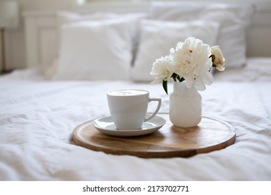 Light cozy bedroom, Coffee or tea cup and an flowers on the white bed. Breakfast in bed. Coffee cup and flowers on a white bed. White Concept. - Shutterstock ID 2173702771