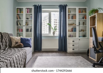 Light cozy teen room with white bookcases,  grey sofa and blue walls