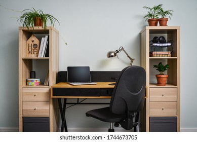 Light cozy teen room with white bookcases, working desk and laptop on it