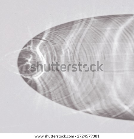 Light creates caustic patterns on a flat glass surface.