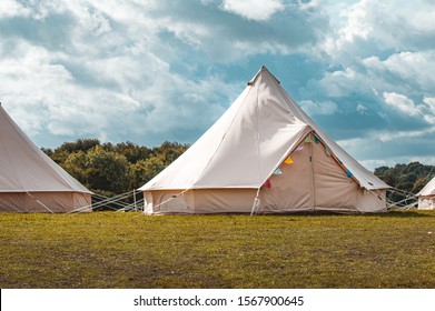 Light creme canvas waterproof tent in a green field on a nice and hot summer day. Blue Clouds, green grass, Child festival tent. - Shutterstock ID 1567900645