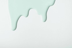 Light Cyan Liquid Drops Of Paint Color Flow Down On Isolated White Background. Abstract Green Backdrop With Fluid Drip Pattern. Acrylic Painting With Copy Space.