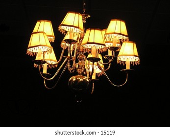 A Light In the Darkness. This Chandelier is in a  small room of a  church. and Is Accented by the total darkness around it.