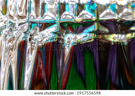 Light of different colors keep converging and diverging at various spots on the inverted whiskey glass