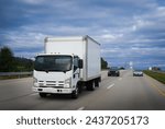 Light duty box truck delivering shipments of goods on highway