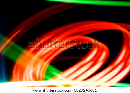 Light effect background. Multicolored luminous tracks in the dark.