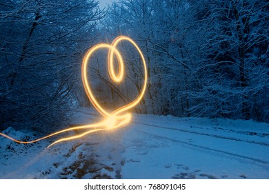 Light effect in the form of a heart. Winter forest at night.