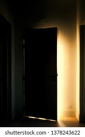 Light At The End Of The Corridor. Bright Warm Light Leaking From An Opened Door. Hope, Dream And Solutions To The Problem Concept. Light Leading Way In A Dark Corridor Path Way.