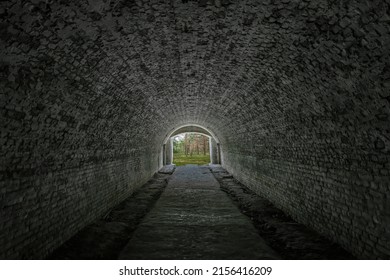 Light at end of dark tunnel. Exit from old stone underpass to green forest