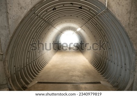 Light at the end of the tunnel. Subway footpath in the Swiss alps.
