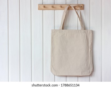 light fabric bag hangs on a white wall. eco bag. space for your text. mockup, scene creator. 