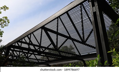 Light Filter Steel Roof Structure. The Black Metal Roof Of The Modern House Filters The Light In The Side View On The Full Frame Natural Background. Selective Focus