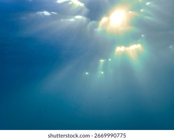 Light filtering down through blue water. Underwater sunlight in deep sea. Light viewed from blue abyss. Underwater sunlight shining deep with ripples on wave surface ocean ray, Mediterranean sea.