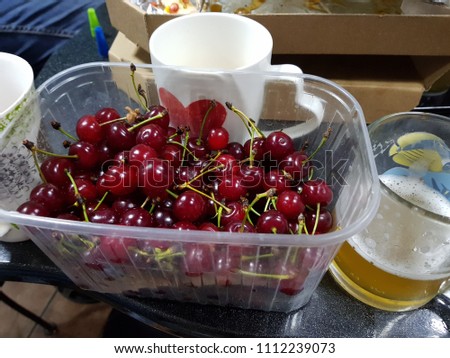 Light fruit craft beer and cherry on wooden chopping board, rustic style