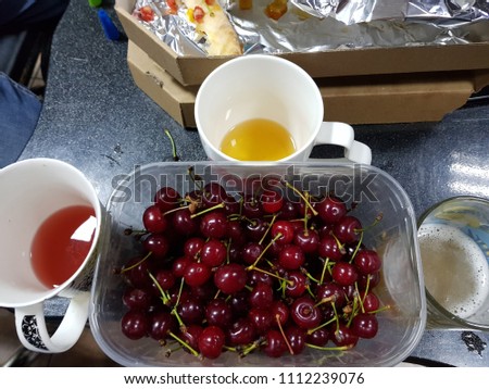 Light fruit craft beer and cherry on wooden chopping board, rustic style