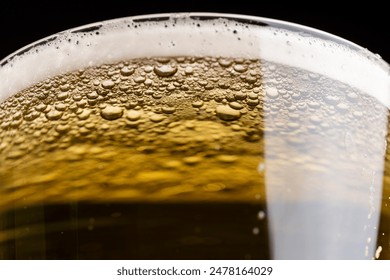 light golden beer in a glass glass on a black background, alcoholic drink beer in a glass glass - Powered by Shutterstock