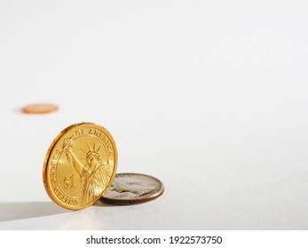 Light gray background on the theme of USA economy, finance and banks with space for text. An American 1 one dollar coin stands on its edge. US coins backdrop with copy-space. Macro
