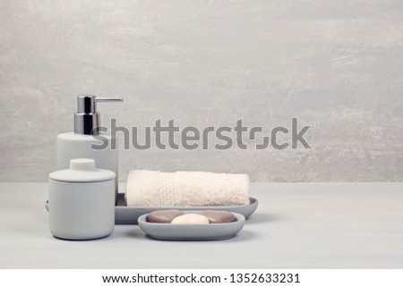 Light gray ceramic acessories for bath - bowl, soap dispenser and other accessories for personal hygiene. Decor for bathroom interior