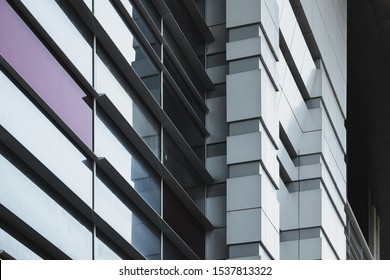 Light Gray Facade Of A Large Building, Geometric Shapes In Architecture, Building Corner, Diagonals, Straight Lines, Windows, Reflection On Glass