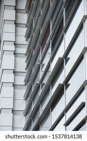 Light Gray Facade Of A Large Building, Geometric Shapes In Architecture, Building Corner, Diagonals, Straight Lines, Windows, Reflection On Glass