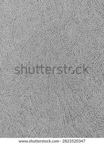 Light gray roughcast plaster wall with fine granular stucco texture and subtle directional marks.