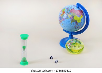 Light green hourglass. Defocused globe and bright toy in the background. Copy space - concept of travel, economy, leisure, business, time - Powered by Shutterstock