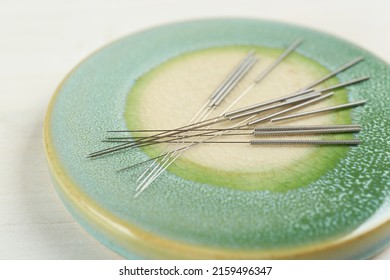 Light Green Stone Coaster With Acupuncture Needles On White Table, Closeup