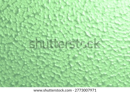A light green surface with a unique bubbly, hammered texture provides a fresh and distinctive background. This image is ideal for modern and creative themes.