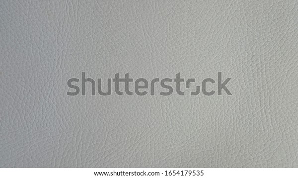 Light grey artificial or synthetic leather\
background with neat texture and copy space, colorful fabric sample\
with leather-like finish aimed for upholstery, fashion, sewing or\
footwear projects
