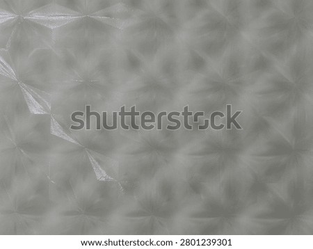 Light grey geometric prism pattern surface with reflective diamond shapes in horizontal orientation