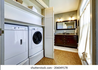 Light Grey Hallway In Old House With Brown Floor Built-in Washer And Dryer In Cabinet