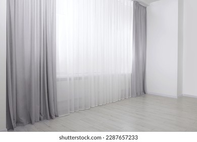 Light grey window curtains and white tulle indoors - Shutterstock ID 2287657233