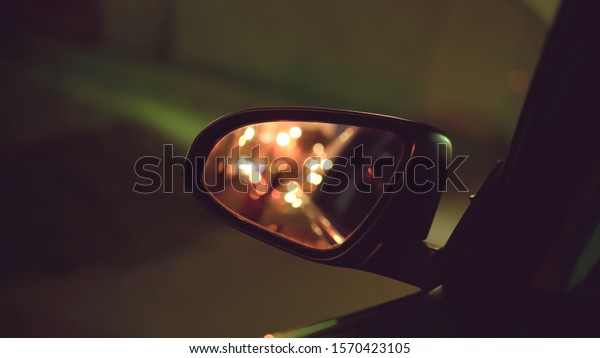 light of headlights car is reflection in car mirror\
at night