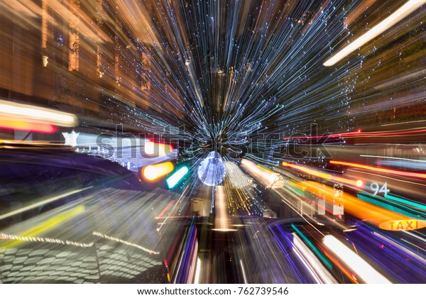 Light headlights, signal lights of cars and street\
lights on the evening road. Light from headlights. Night traffic\
long exposure. Abstract image of speed motion on the road at dark.\
Beautiful rays.