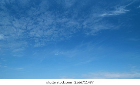 Light high clouds slide on sky. Layer of clouds in blue sky moving horizontal in opposite direction. Timelapse.