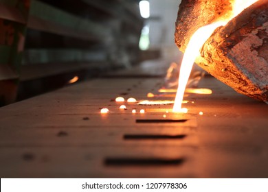 Light from high temperature Iron molten metal pouring in green sand mold ;Foundry process to manufacture cast product for automotive and electrical; industrial engineering metallurgy background ,  - Shutterstock ID 1207978306