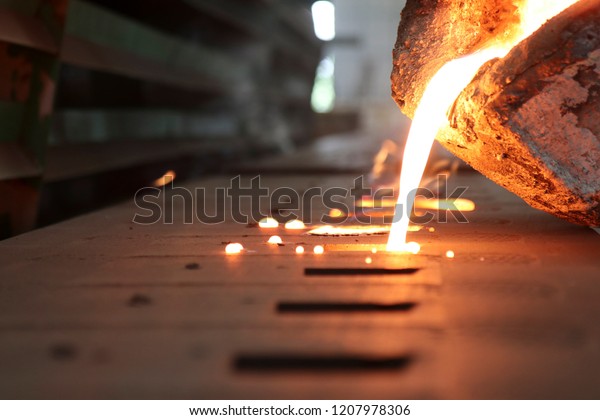 Light from high temperature Iron molten metal pouring in\
green sand mold ;Foundry process to manufacture cast product for\
automotive and electrical; industrial engineering metallurgy\
background , 