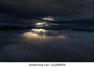 Light of hope. Concept photo with the sun rays bursting out of the clouds. Aerial view between the layers of clouds. - Powered by Shutterstock