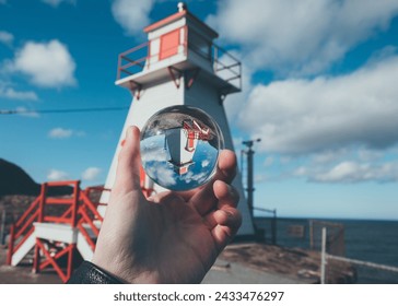 Light house on coast with hand and glass ball - Powered by Shutterstock