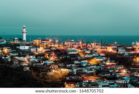 light house on dark night at harbor villiage in southkorea.