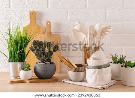 Light kitchen background with wooden eco-friendly kitchen utensils. different green potted plants. eco-friendly modern kitchen space. Cozy home