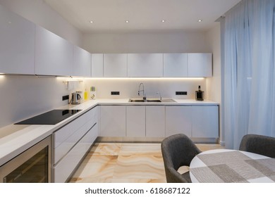 Light kitchen with marble floor, dinning room with round table and chairs, stock photo