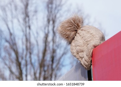 The Light Knitted Hat Was Lost Or Forgotten And Hung Over The Fence. Warehouse Lost And Found, Lost Things, Inattentive Or Forgetful People.