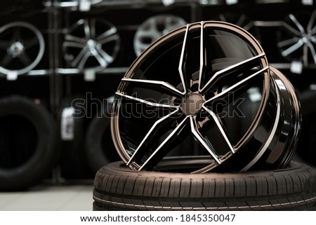 Light large sports alloy wheel on the background of a tire store, close-up.