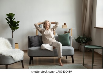 In Light Living Room On Modern Comfy Couch Rest Aged Woman, Grandma Closed Eyes Enjoy Peace And Placidity, Put Hands Behind Head Breath Fresh Humidifier Air. No Stress, Carefree Retired Life Concept